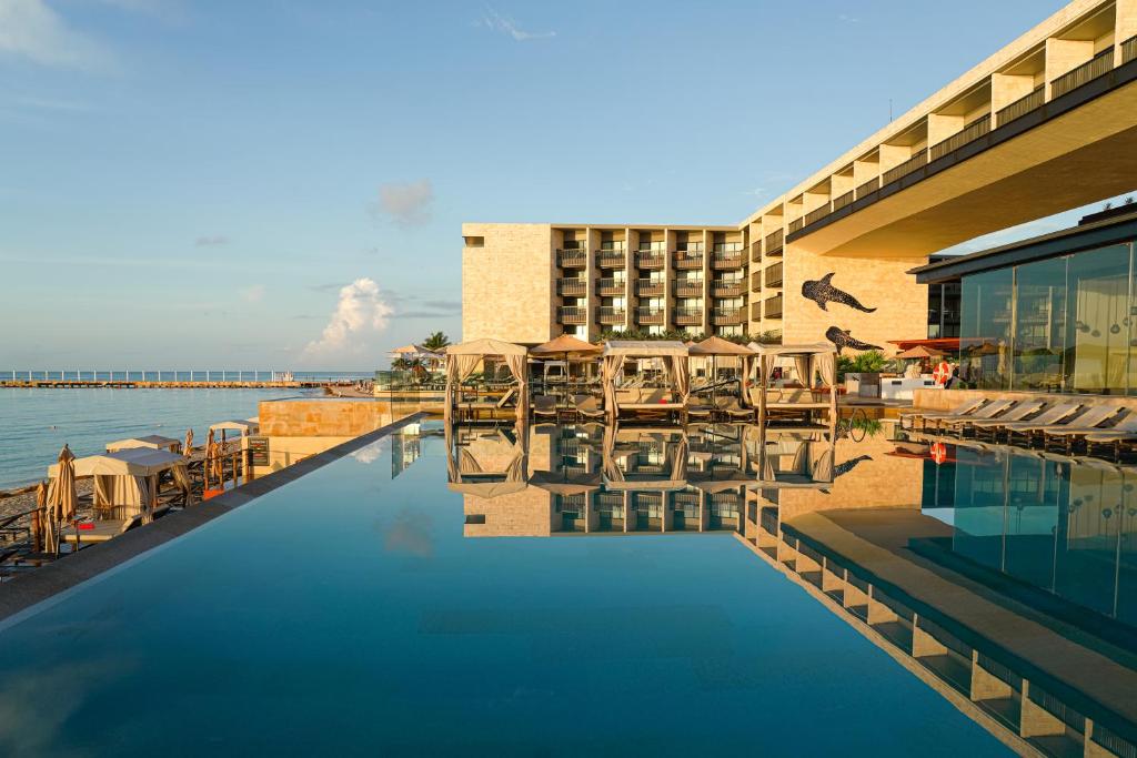 a hotel with a swimming pool next to the water at Grand Hyatt Playa del Carmen Resort in Playa del Carmen