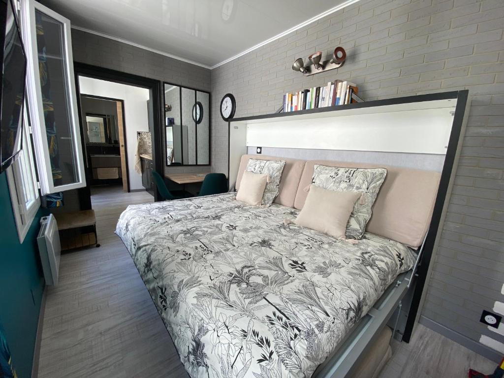een slaapkamer met een groot bed in een kamer bij Le Chanzy Proche des Thermes et de la Gare in Rochefort