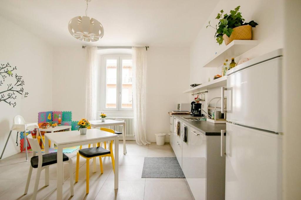 uma cozinha com uma pequena mesa e uma cozinha com electrodomésticos brancos em Guesthouse Tree Rooms Modern em Bérgamo