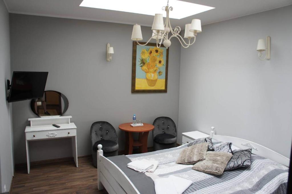 a bedroom with a bed and a table with chairs at Hotelik Kościerzyna in Kościerzyna