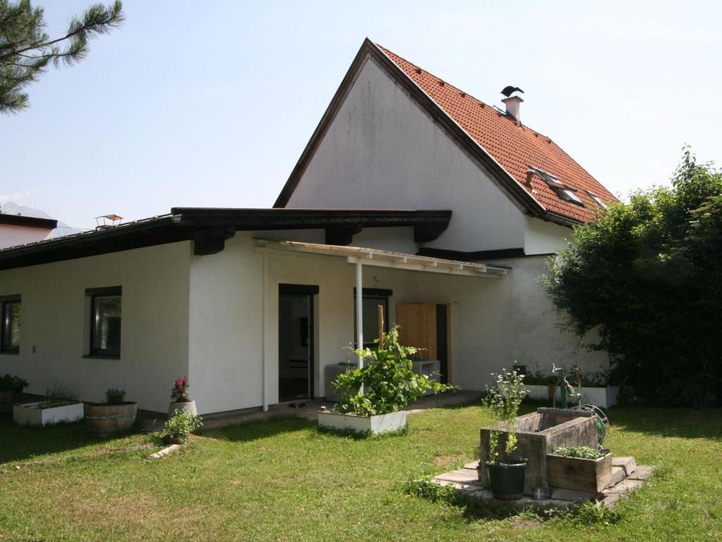 een klein wit huis met een grasveld bij Apartment Diwani home stay Innsbruck by Interhome in Innsbruck