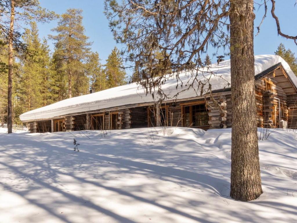 a log cabin with a snow covered roof at Holiday Home Sallan savu e by Interhome in Salla