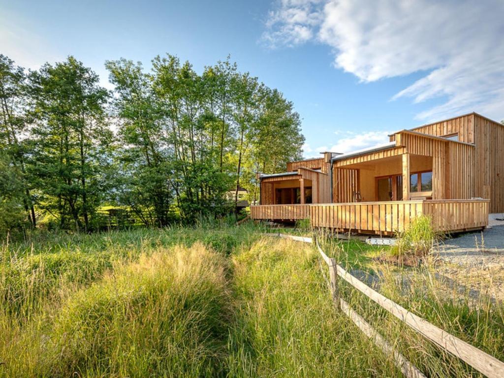une maison en bois dans un champ avec une clôture dans l'établissement Apartment Glamping Lodge A by Interhome, à Ossiach