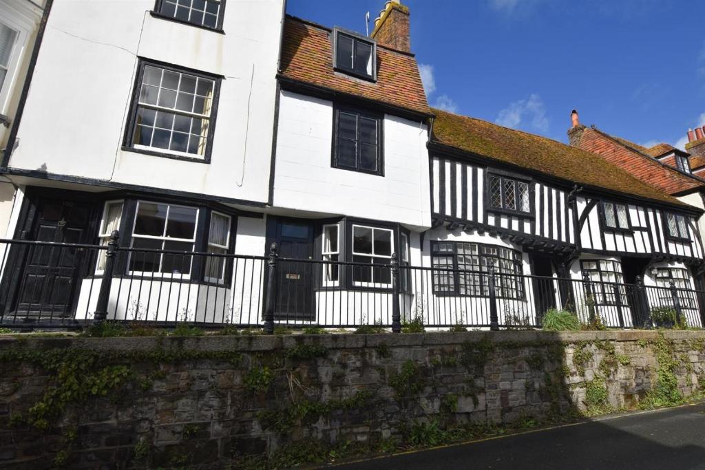 a white and black house with a fence at Hastings Old town Cottage style in Hastings