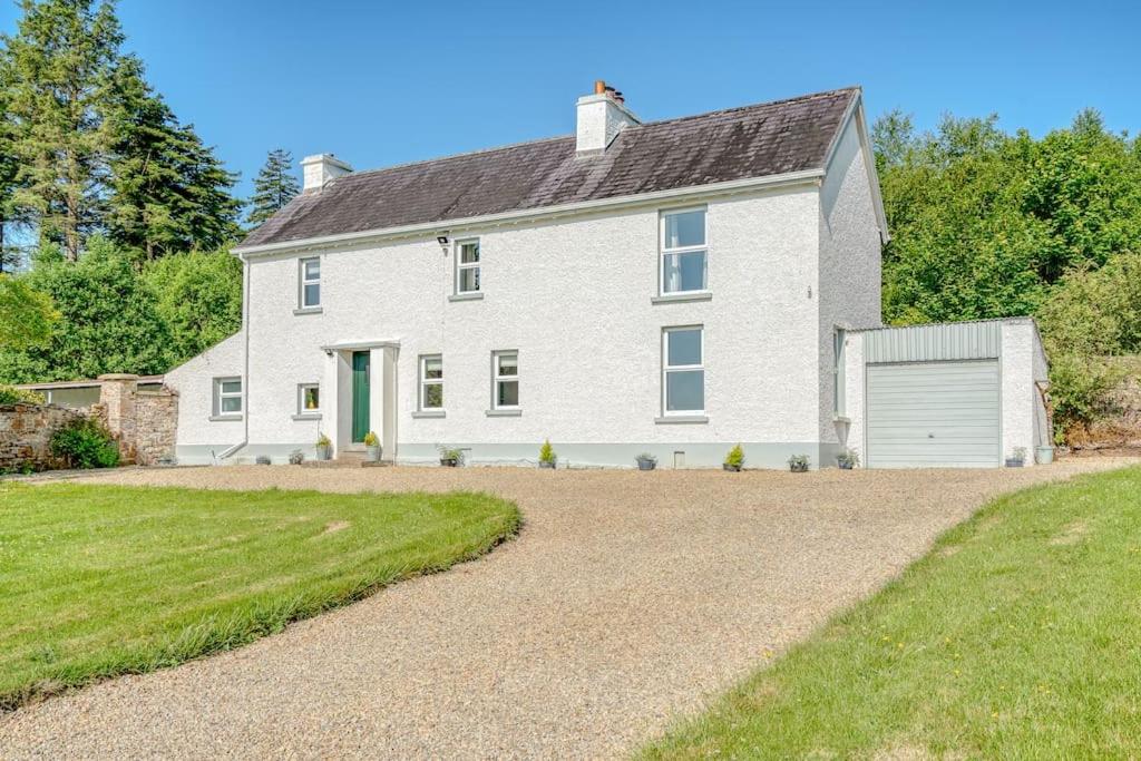 uma grande casa branca com uma entrada em Eala House em Donegal