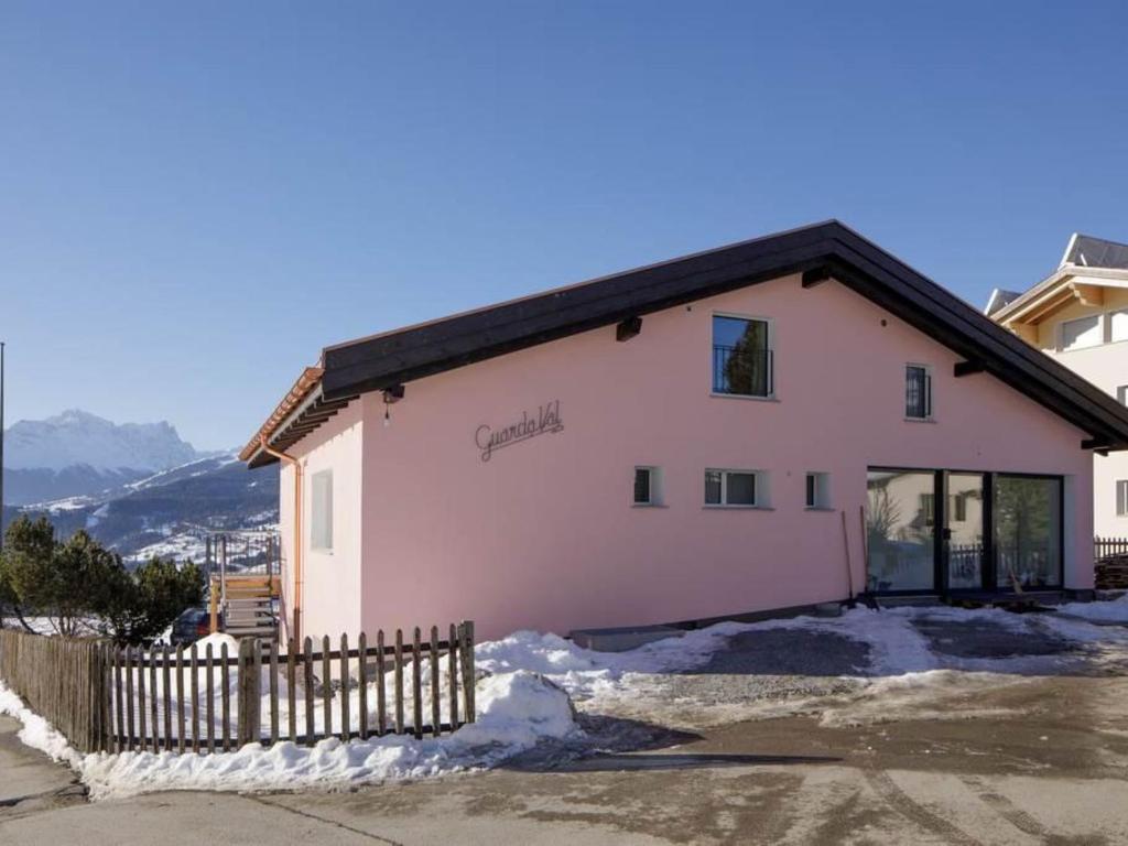 une maison rose avec une clôture devant elle dans l'établissement Apartment Guarda Val Müller Lärchensitz by Interhome, à Lenz