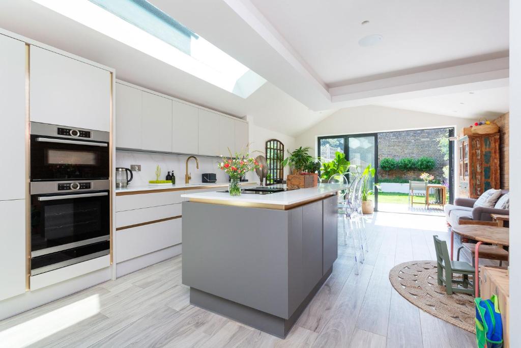 a kitchen with white cabinets and a kitchen island at Veeve - Exalted Living in London