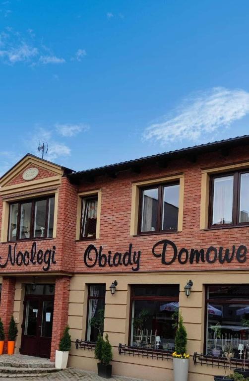 a red brick building with a sign that reads oldest daddyowment at Hotelik Kościerzyna in Kościerzyna