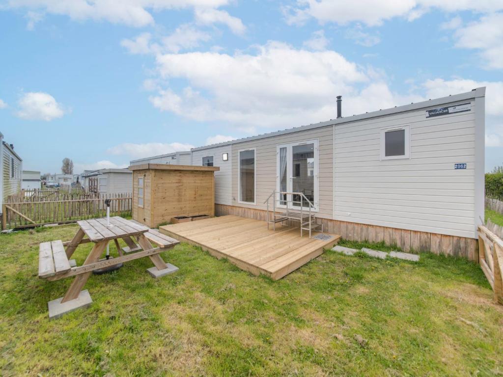 una casa pequeña con terraza y mesa de picnic en Holiday Home secci beach by Interhome, en Bredene