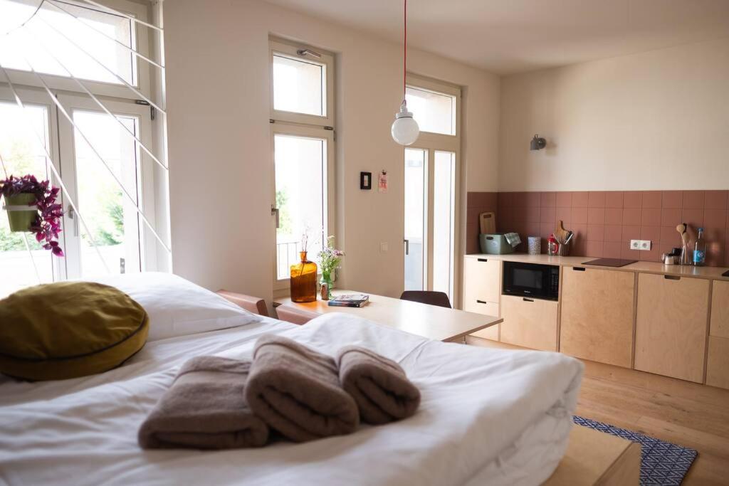Un dormitorio con una cama blanca con toallas. en Lax und Sülze, en Leipzig