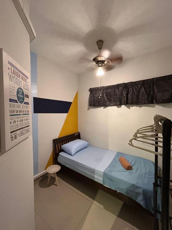 - une chambre avec un lit et un ventilateur de plafond dans l'établissement Mabuti homestay, à Donggongon