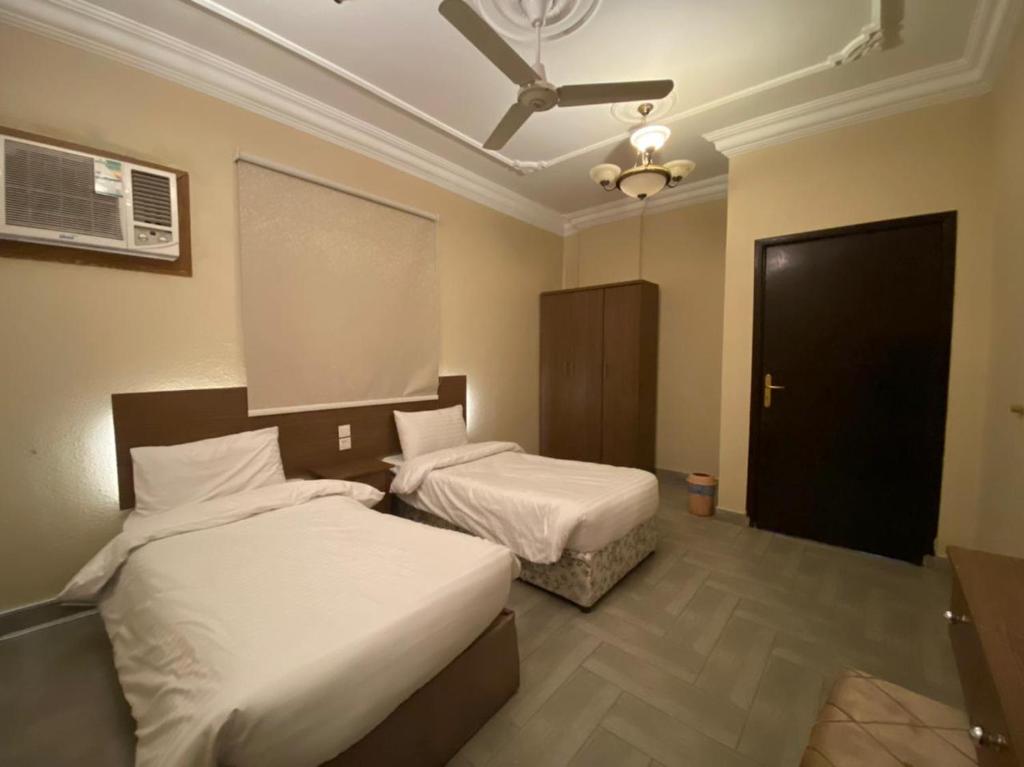 a bedroom with two beds and a ceiling fan at فيفيندا أحلى مكان خميس مشيط in Khamis Mushayt