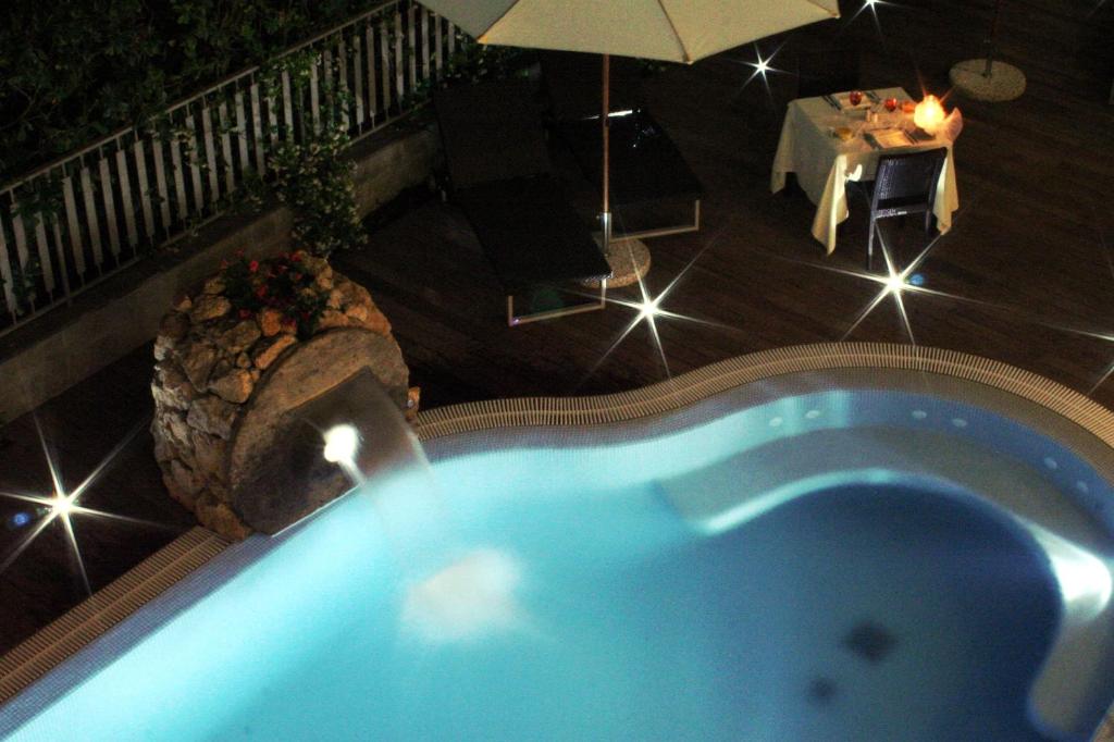 an overhead view of a swimming pool with an umbrella at Hotel La Pigna in Marina di Pietrasanta
