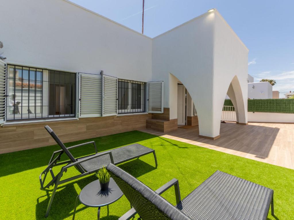 a patio with grass and chairs on a house at Holiday Home Noelia by Interhome in Torredembarra
