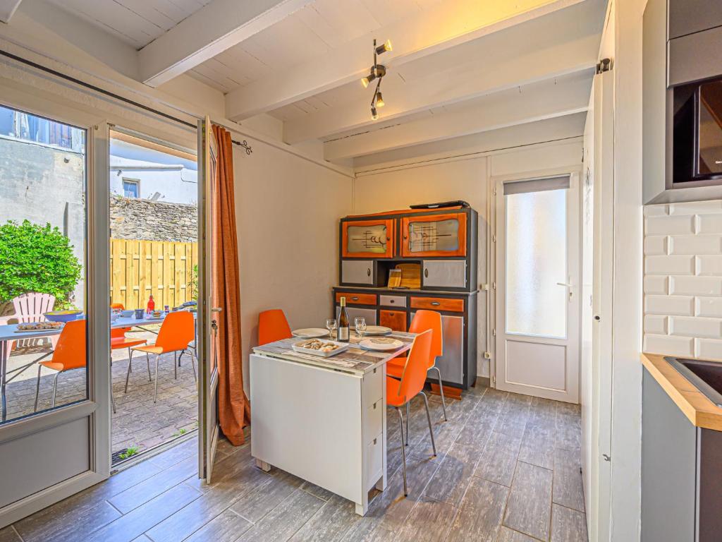 uma cozinha com cadeiras laranja e uma mesa em Holiday Home Maison Des Lilas by Interhome em Quiberon