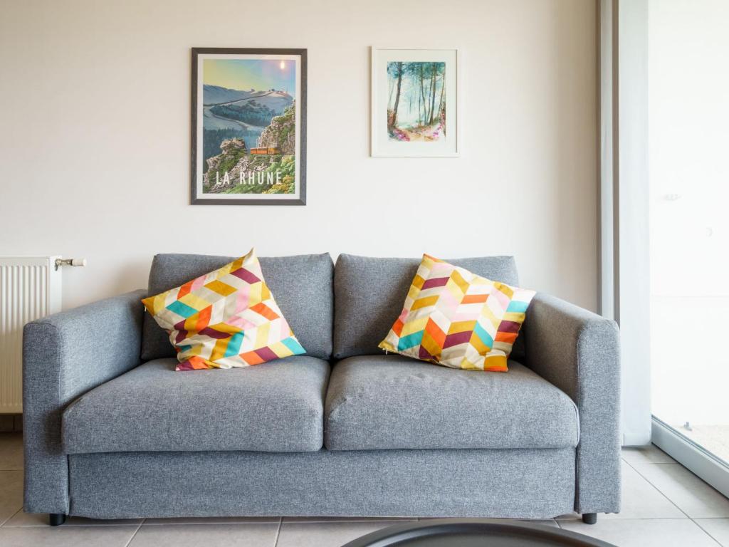 a gray couch with colorful pillows in a living room at Apartment Rivadour 2 by Interhome in Bayonne