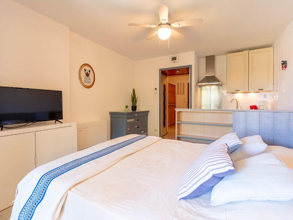 Cet appartement comprend une chambre avec un lit blanc et une cuisine. dans l'établissement Studio Les Regates-3 by Interhome, à Hyères