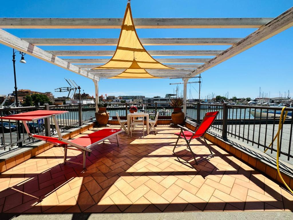 a deck with chairs and a table and a sail at Clementina House in Fiumicino