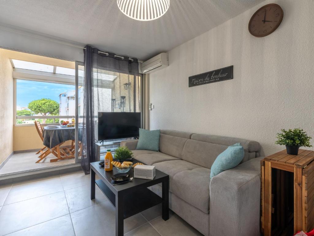 ein Wohnzimmer mit einem Sofa und einem Tisch in der Unterkunft Apartment Los Amigos-14 by Interhome in Le Grau-du-Roi