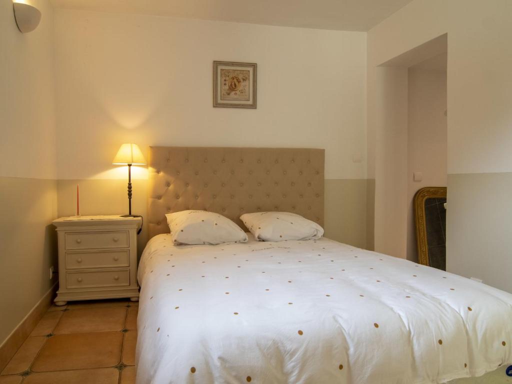 a bedroom with a bed with a white bedspread and a lamp at Holiday Home La Bastide by Interhome in Tourves