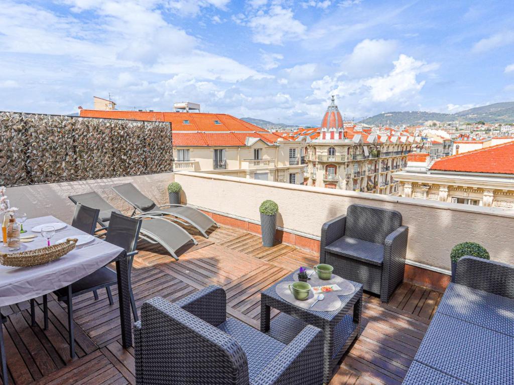 d'un balcon sur le toit avec des tables et des chaises. dans l'établissement Apartment Les terrasses de l'Escurial by Interhome, à Nice