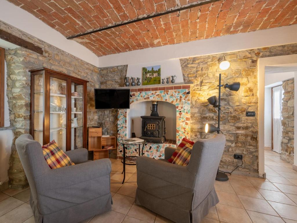 a living room with a stone wall with chairs and a fireplace at Apartment Casa Domenica by Interhome in Monastero Bormida