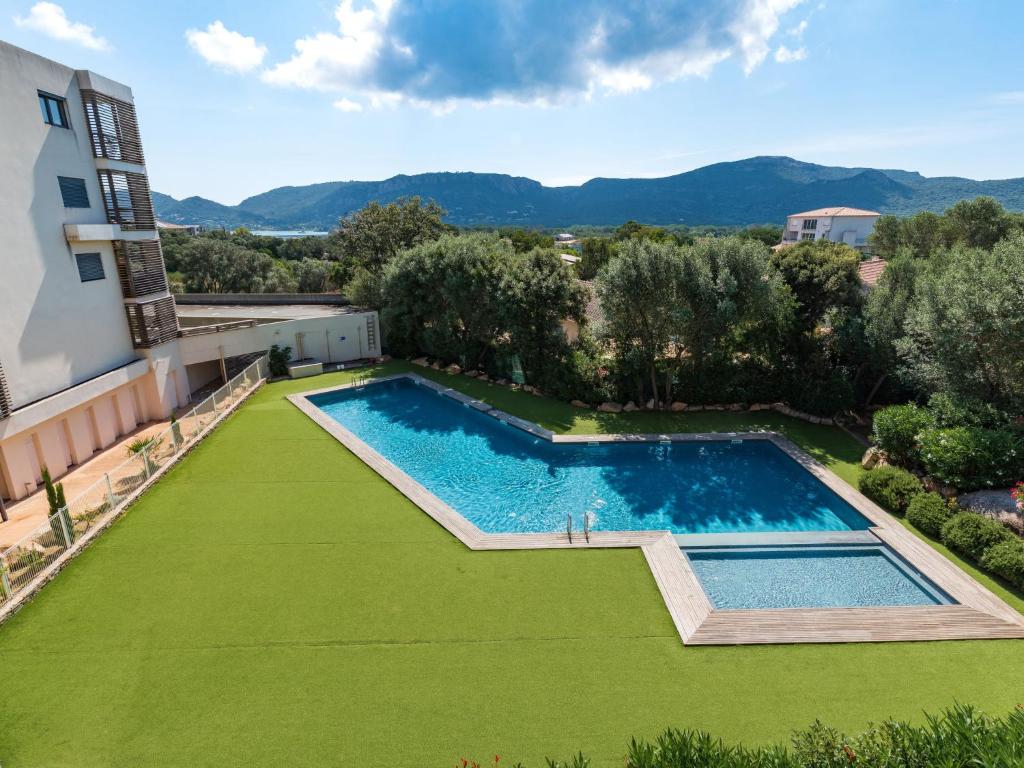 - une vue sur la piscine et sa pelouse verdoyante dans l'établissement Apartment Cita Di Sali 58 by Interhome, à Porto-Vecchio