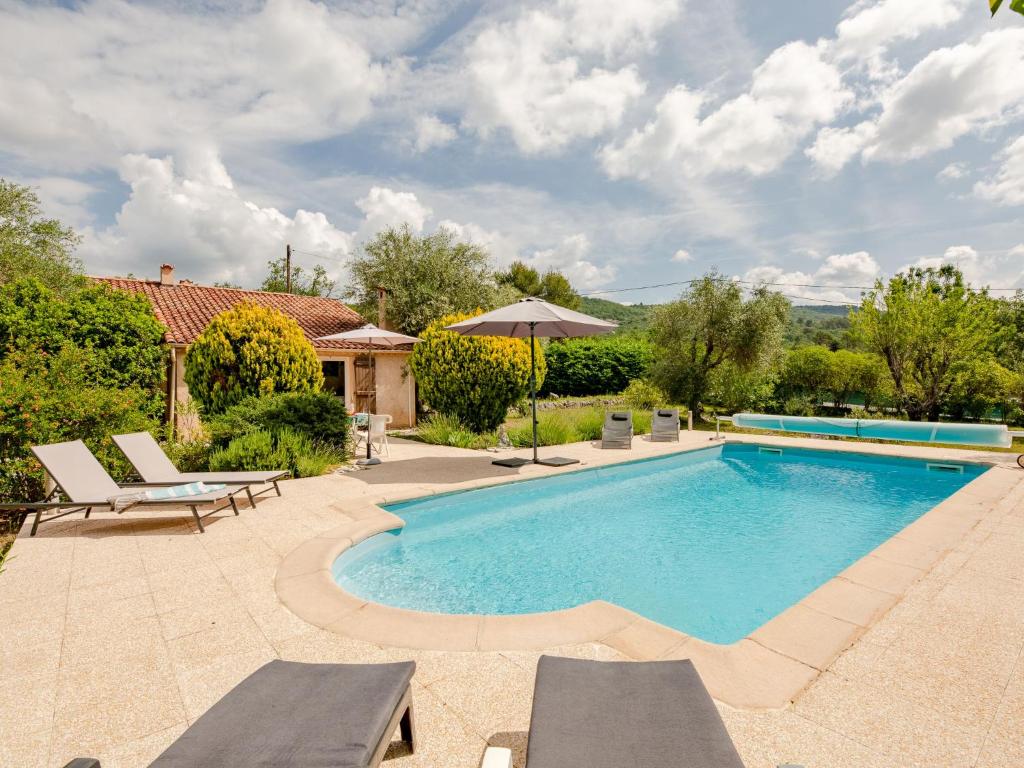 - une piscine dans une cour avec des chaises et un parasol dans l'établissement Holiday Home Kerylou by Interhome, à Saint-Cézaire-sur-Siagne