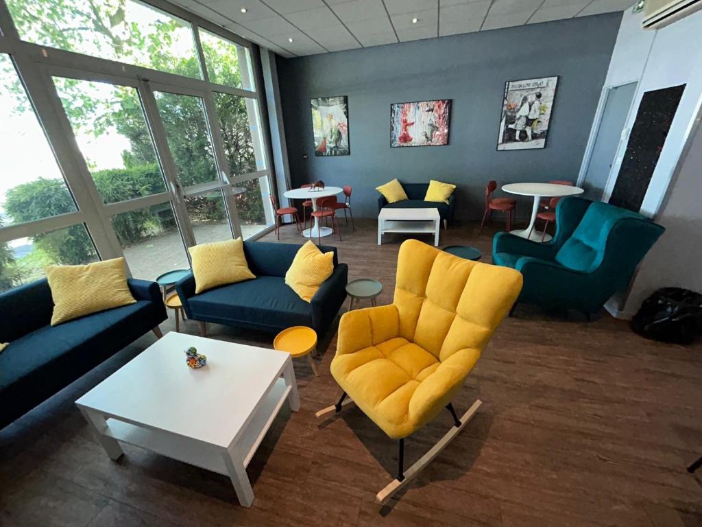 a living room with blue couches and yellow chairs at Kyriad Marne-La-Vallée Torcy in Torcy