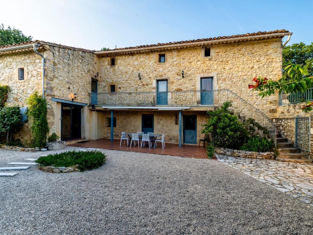 a large stone house with a patio and stairs at Holiday Home Le Mas d&#39;Adélaïs by Interhome in Baron