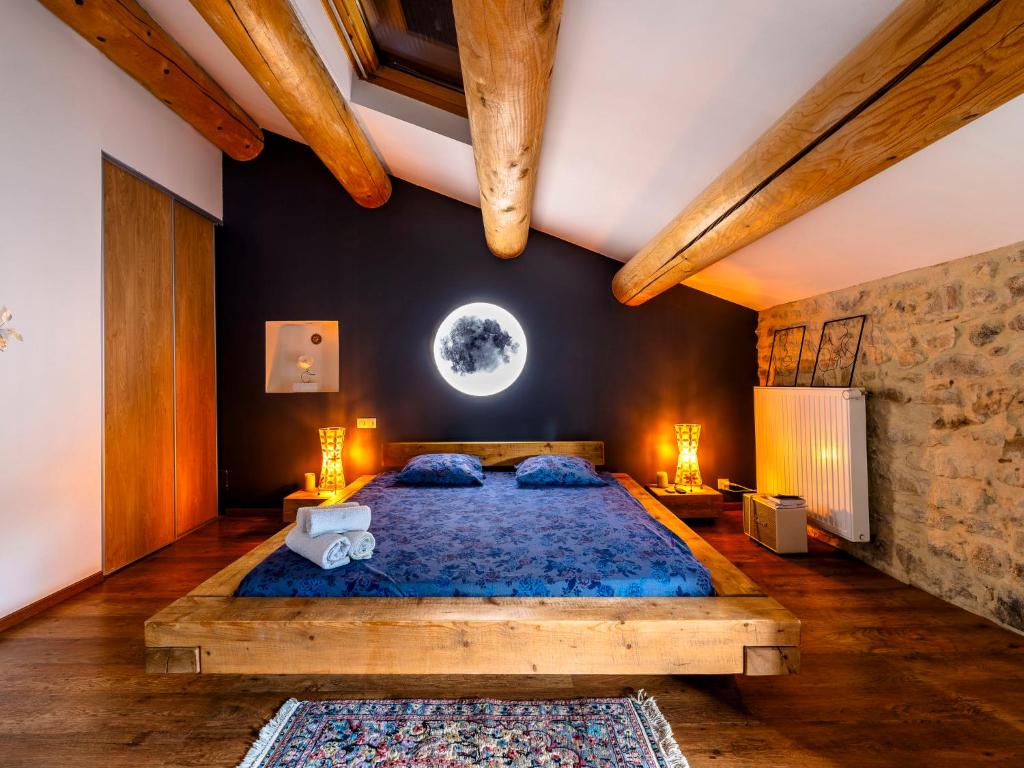 a bedroom with a large bed with a blue bedspread at Holiday Home Le Mas d&#39;Adélaïs by Interhome in Baron