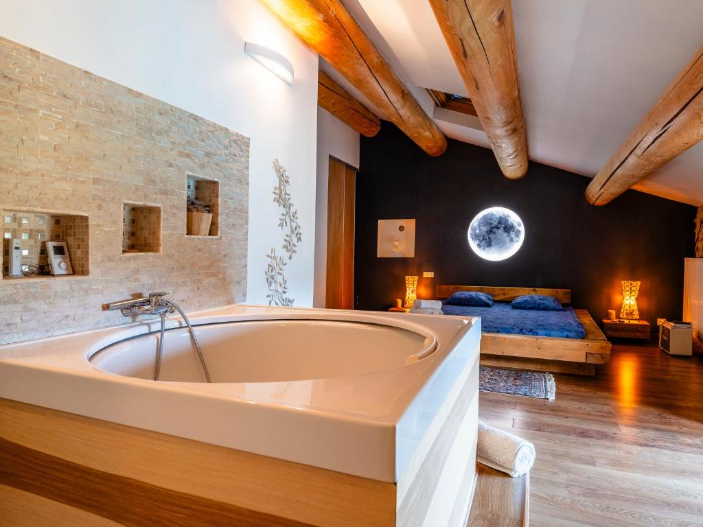 a large bath tub in a room with a bed at Holiday Home Le Mas d&#39;Adélaïs by Interhome in Baron