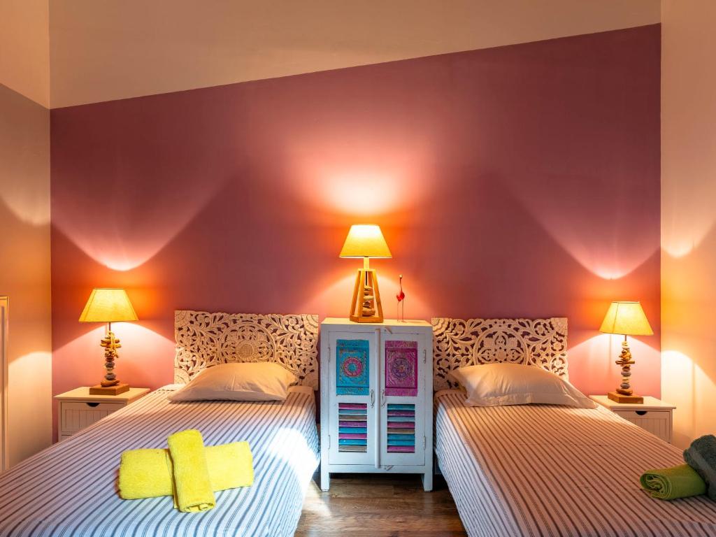 two beds in a bedroom with purple walls and lamps at Holiday Home Le Mas d&#39;Adélaïs by Interhome in Baron