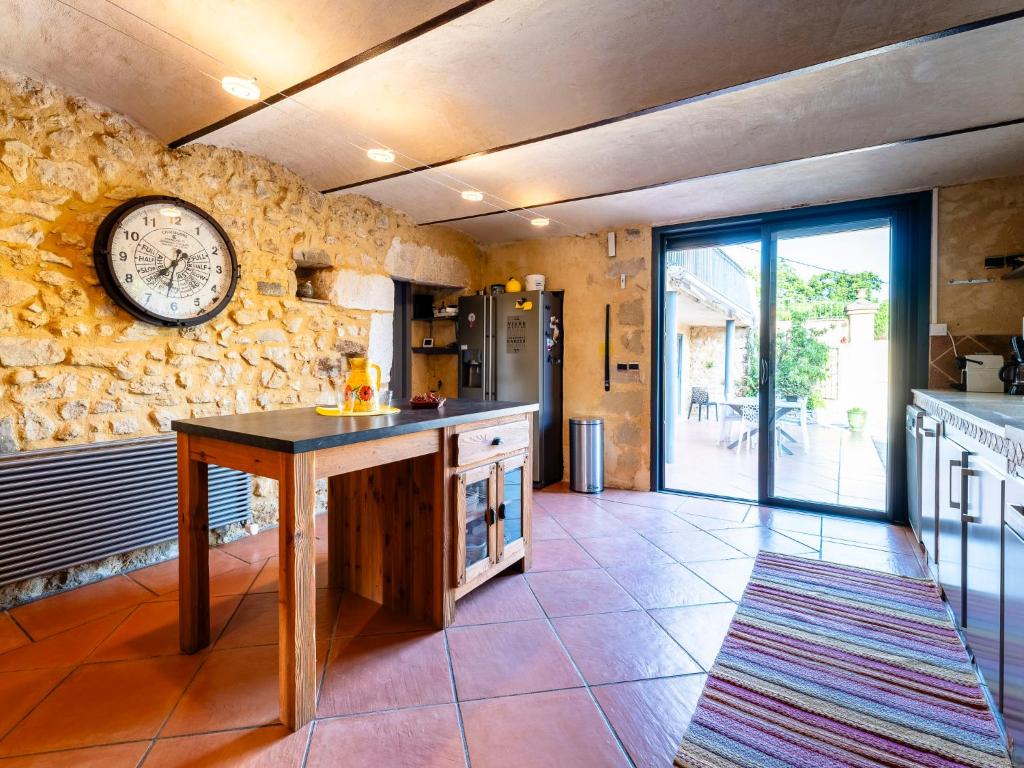 a kitchen with a clock on a stone wall at Holiday Home Le Mas d&#39;Adélaïs by Interhome in Baron