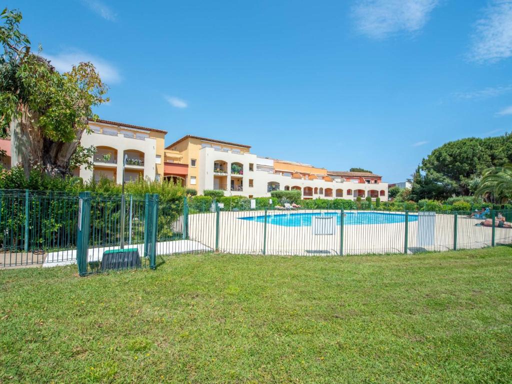 une clôture avec une piscine en face d'une maison dans l'établissement Apartment Les Lavandiers by Interhome, à Cavalaire-sur-Mer