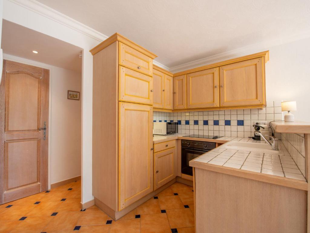 a kitchen with wooden cabinets and a counter top at Apartment Les Lavandiers by Interhome in Cavalaire-sur-Mer