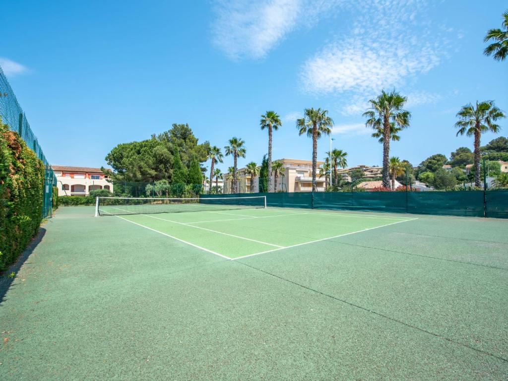 a tennis court with palm trees in the background at Apartment Les Lavandiers by Interhome in Cavalaire-sur-Mer