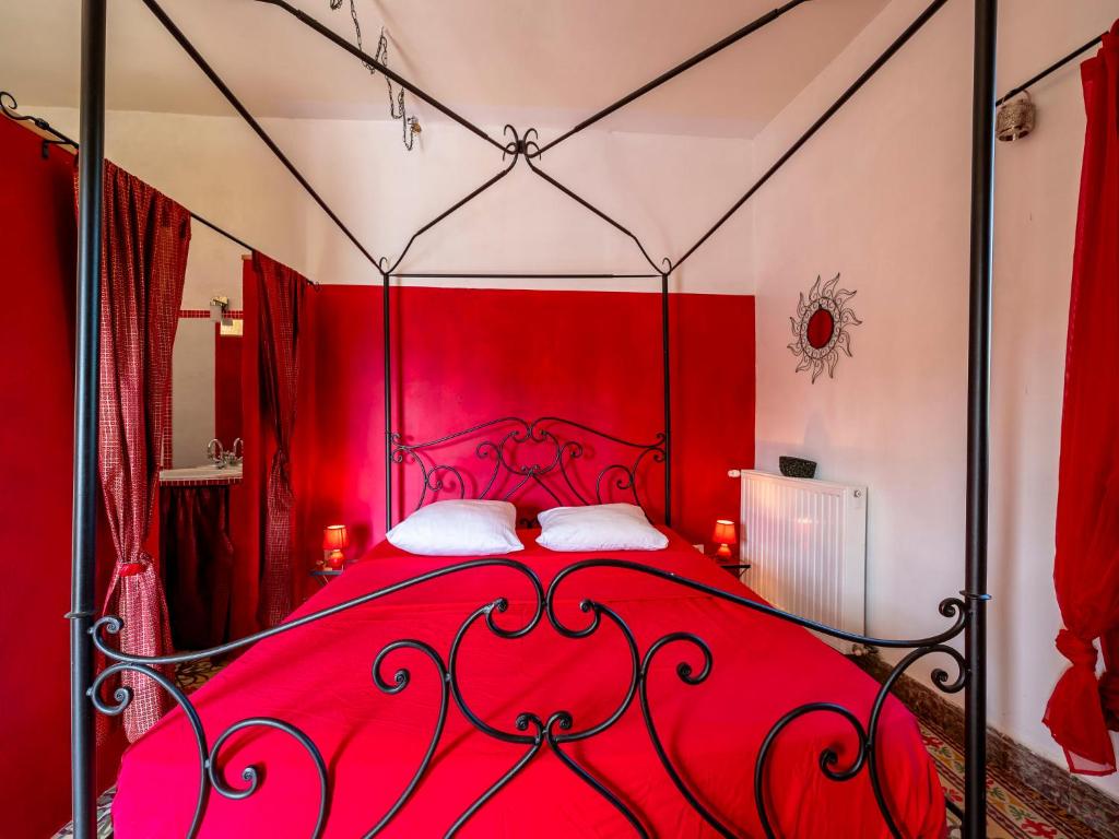 a red bed with a red headboard in a room at Holiday Home Le Mas d&#39;Adélaïs by Interhome in Baron