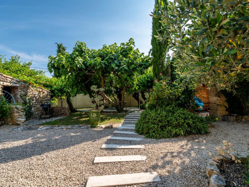 a garden with a stone pathway and trees at Holiday Home Le Mas d&#39;Adélaïs by Interhome in Baron