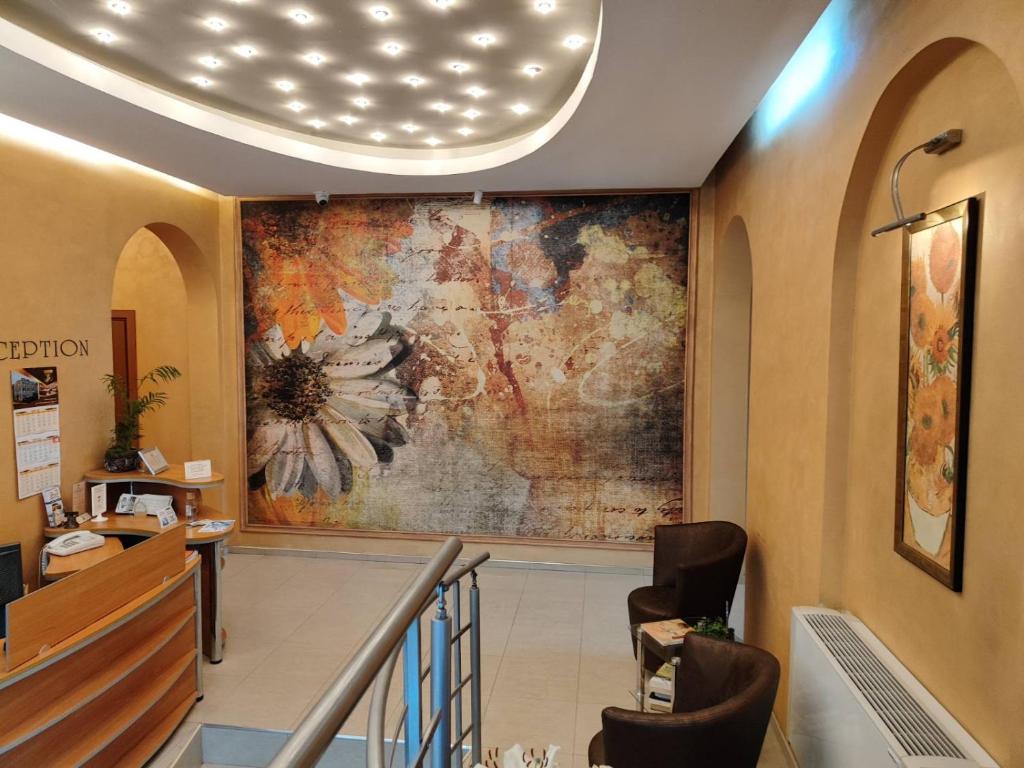 a lobby with a large painting on the wall at Семеен Хотел "Булаир" in Burgas