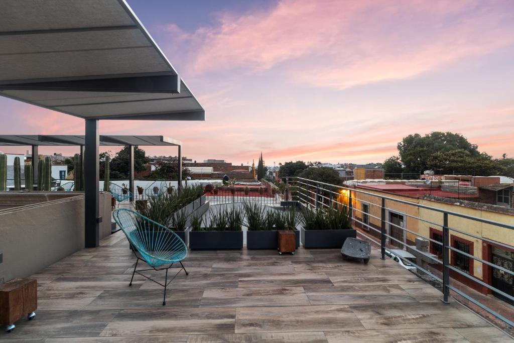 a patio on the roof of a building with a chair at Casa Antigua by Domi Housing in Querétaro