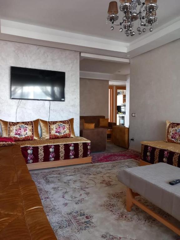 a large living room with two beds and a couch at Bel Appartement à Mansbay in Mansouria