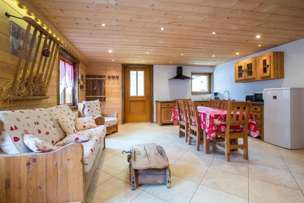 a living room with a couch and a table and a kitchen at Appartement les murailles in Morzine
