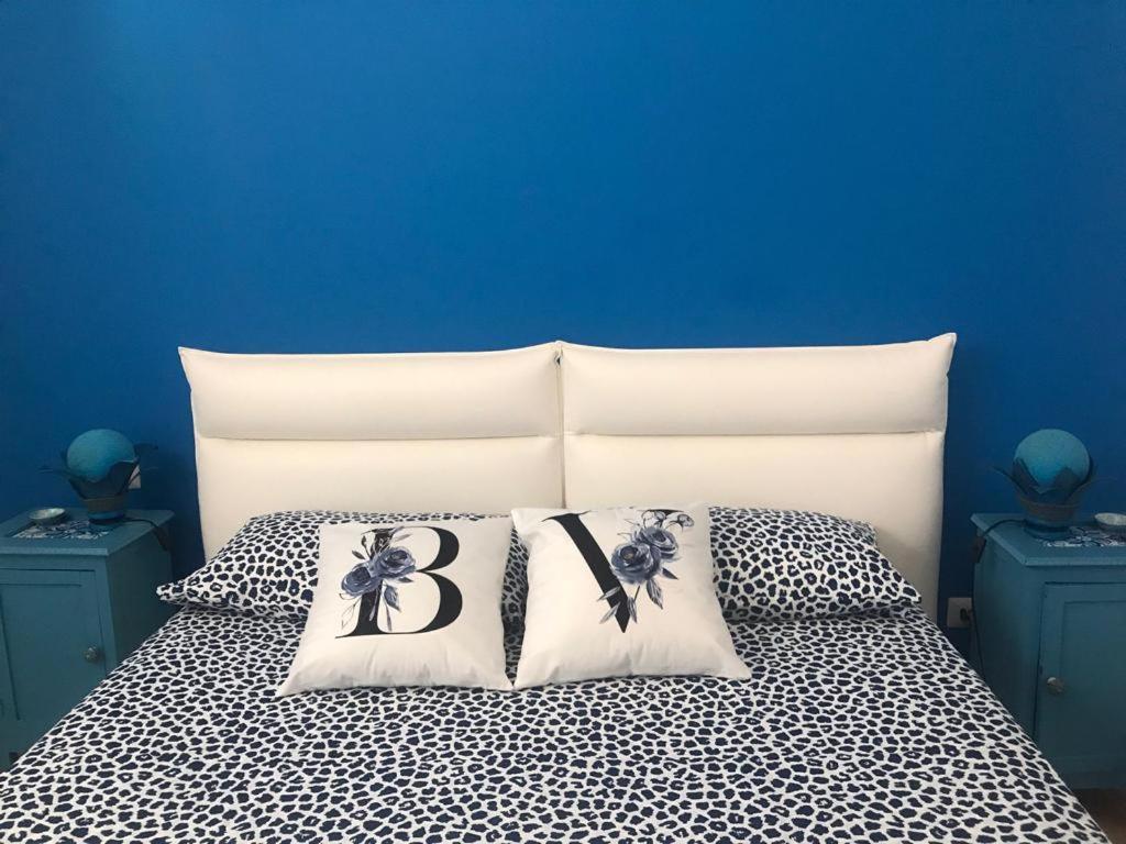 una cama con dos almohadas con la letra b en ella en Blue Velvet, en Punta Secca