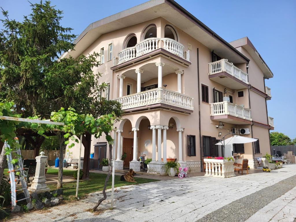 un grand bâtiment rose avec un balcon. dans l'établissement B&B Magna Grecia, à Lamezia Terme