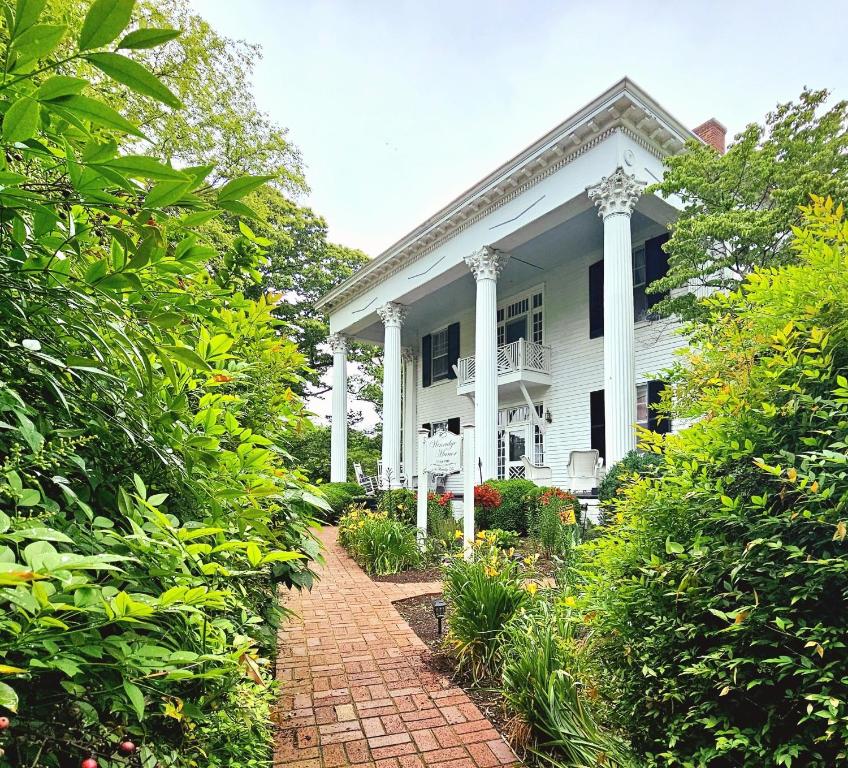 a white house with a brick path in front of it at Winridge Manor in Madison Heights