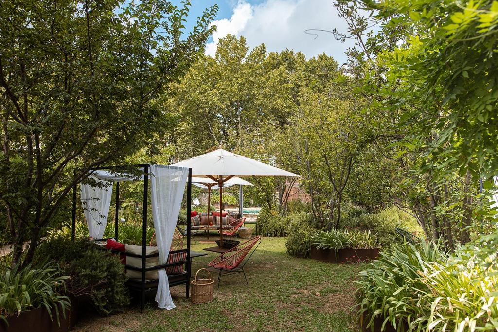 巴塞隆納的住宿－普里梅羅第一酒店，庭院配有遮阳伞和桌椅。