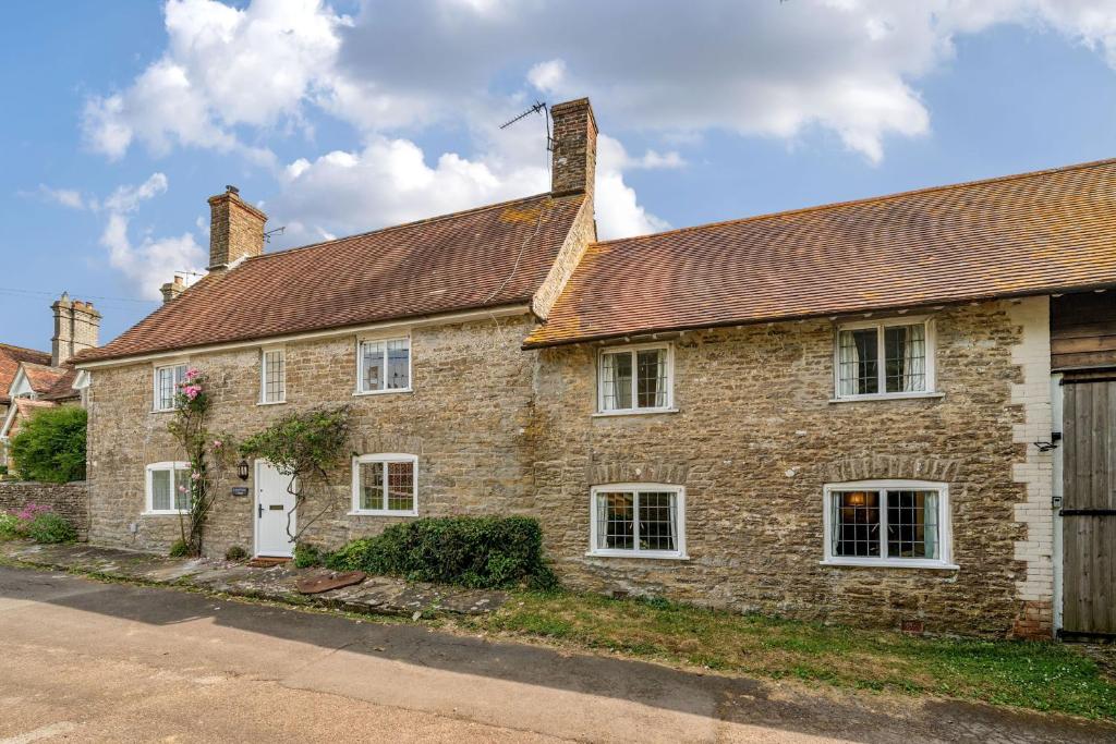 an old brick house with a brown roof at Lower Farm Cottage 