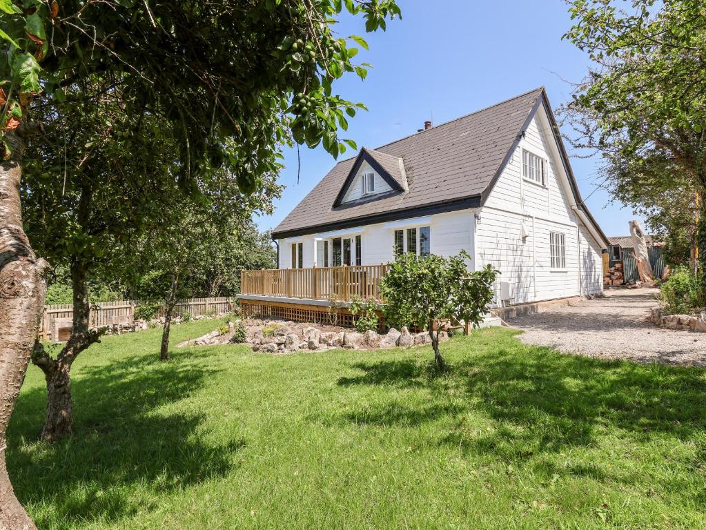 a white house with a yard with trees at Melbecks in Abergele