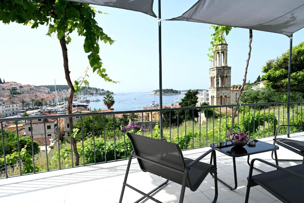 a balcony with chairs and a view of the city at House La Vista Hvar in Hvar